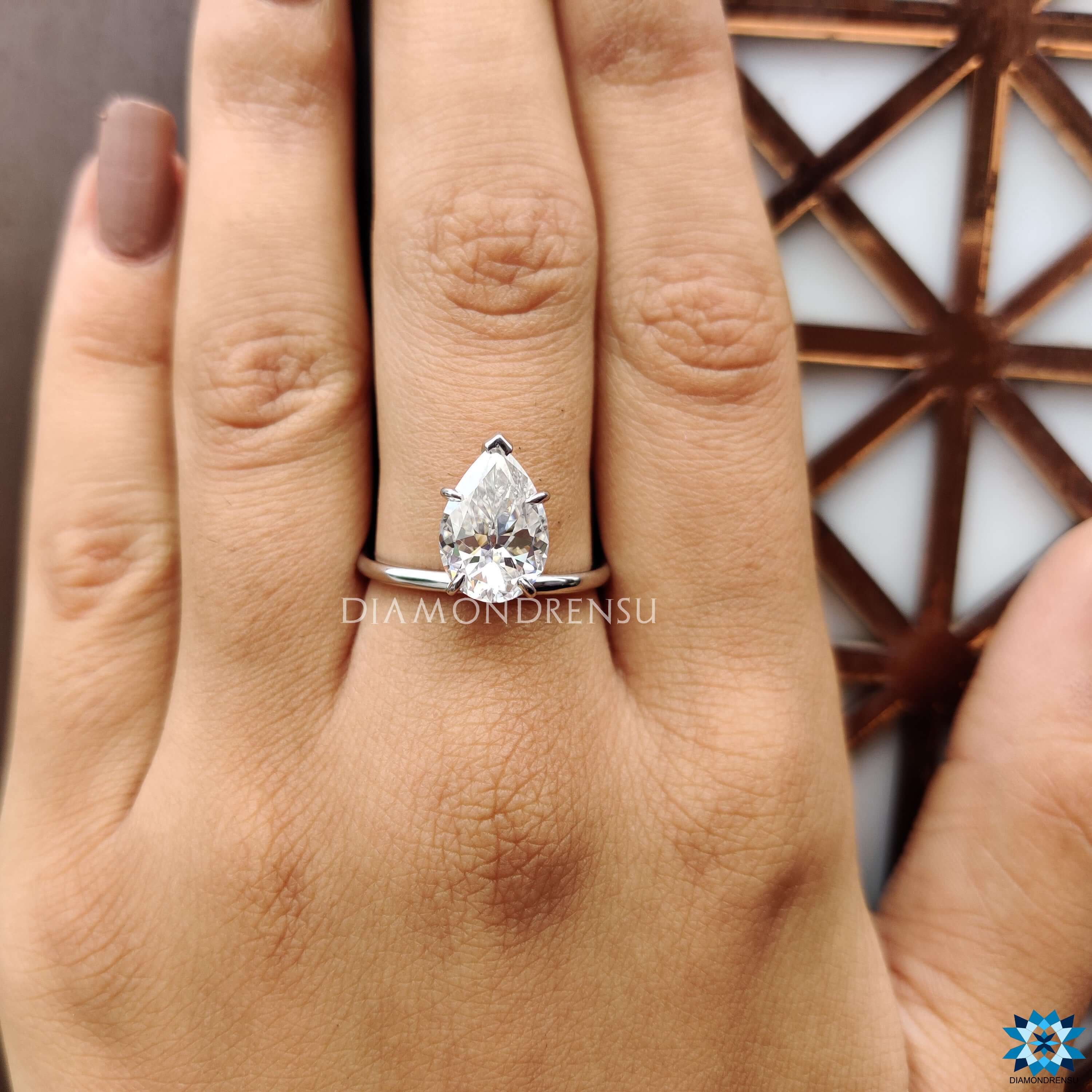Solitaire setting ring with pear moissanite in custom upside down style.