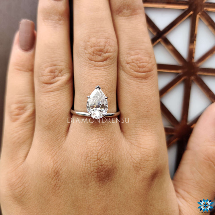 Solitaire setting ring with pear moissanite in custom upside down style.