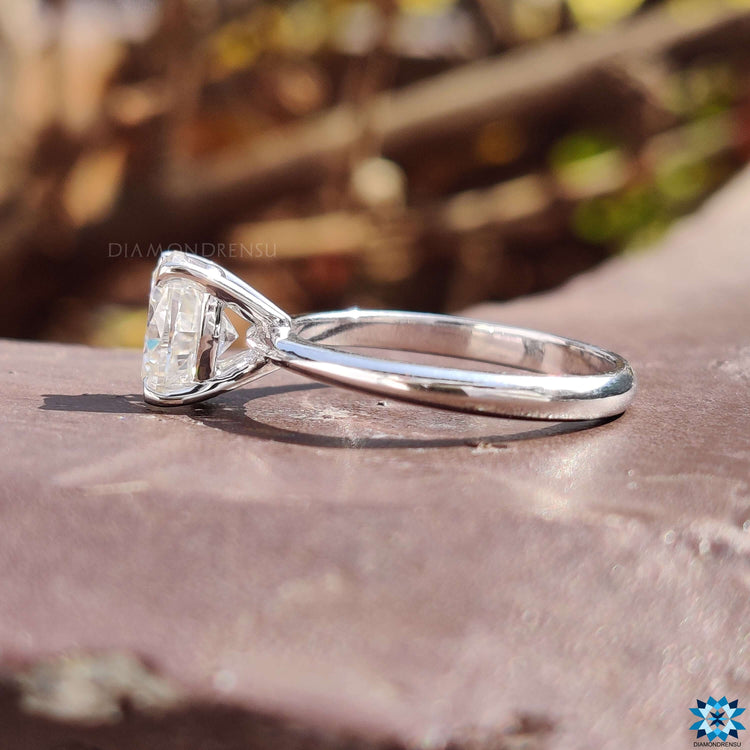 Elegant white gold ring with solitaire oval moissanite and claw prongs.