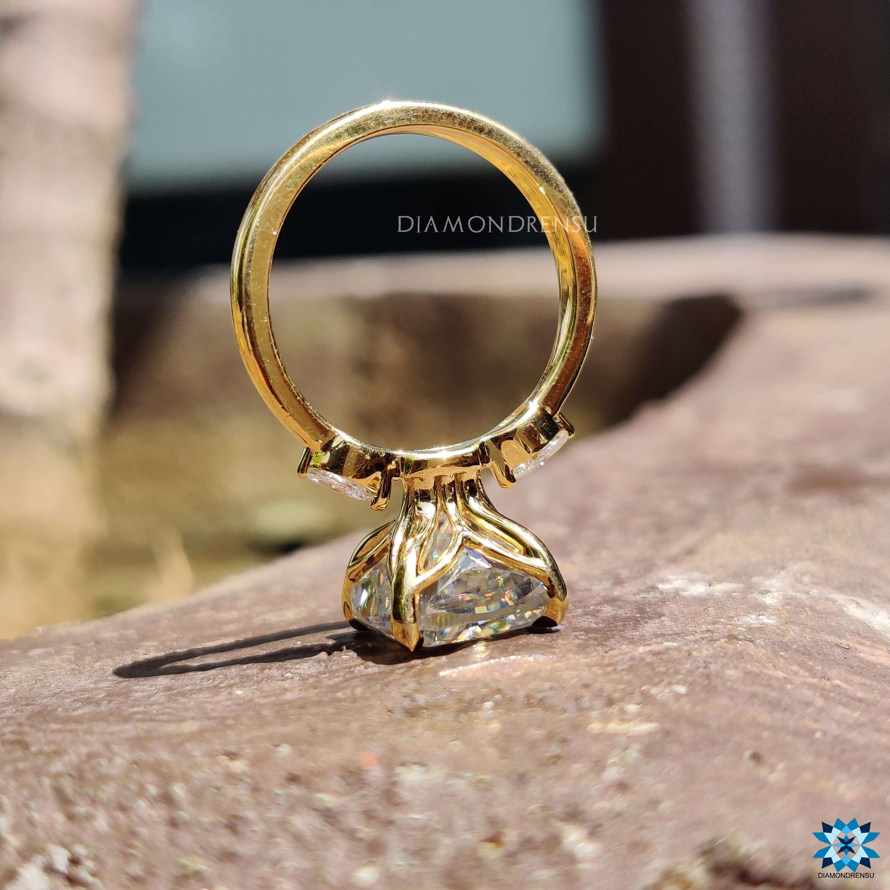 Buy moissanite ring in a three stone design with pear accents and yellow gold.