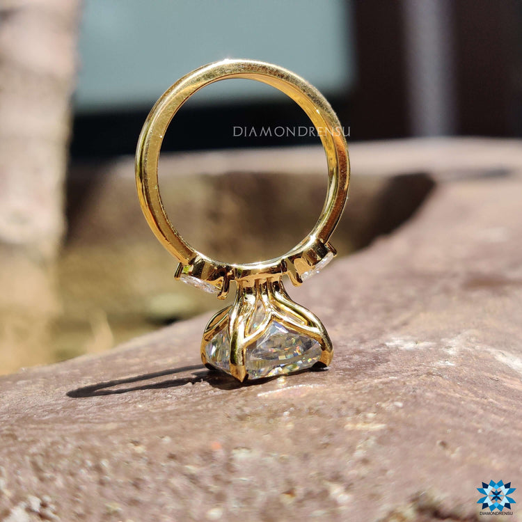 Buy moissanite ring in a three stone design with pear accents and yellow gold.