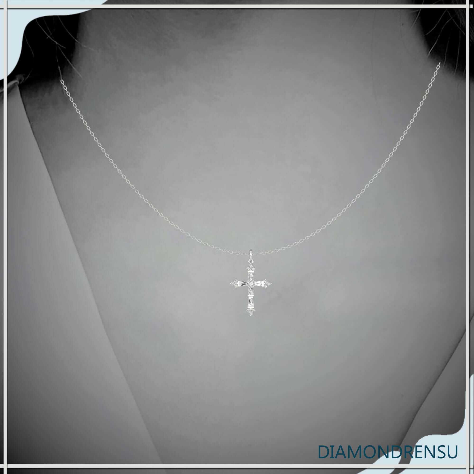 White gold round cross pendant with tapered baguette diamonds.