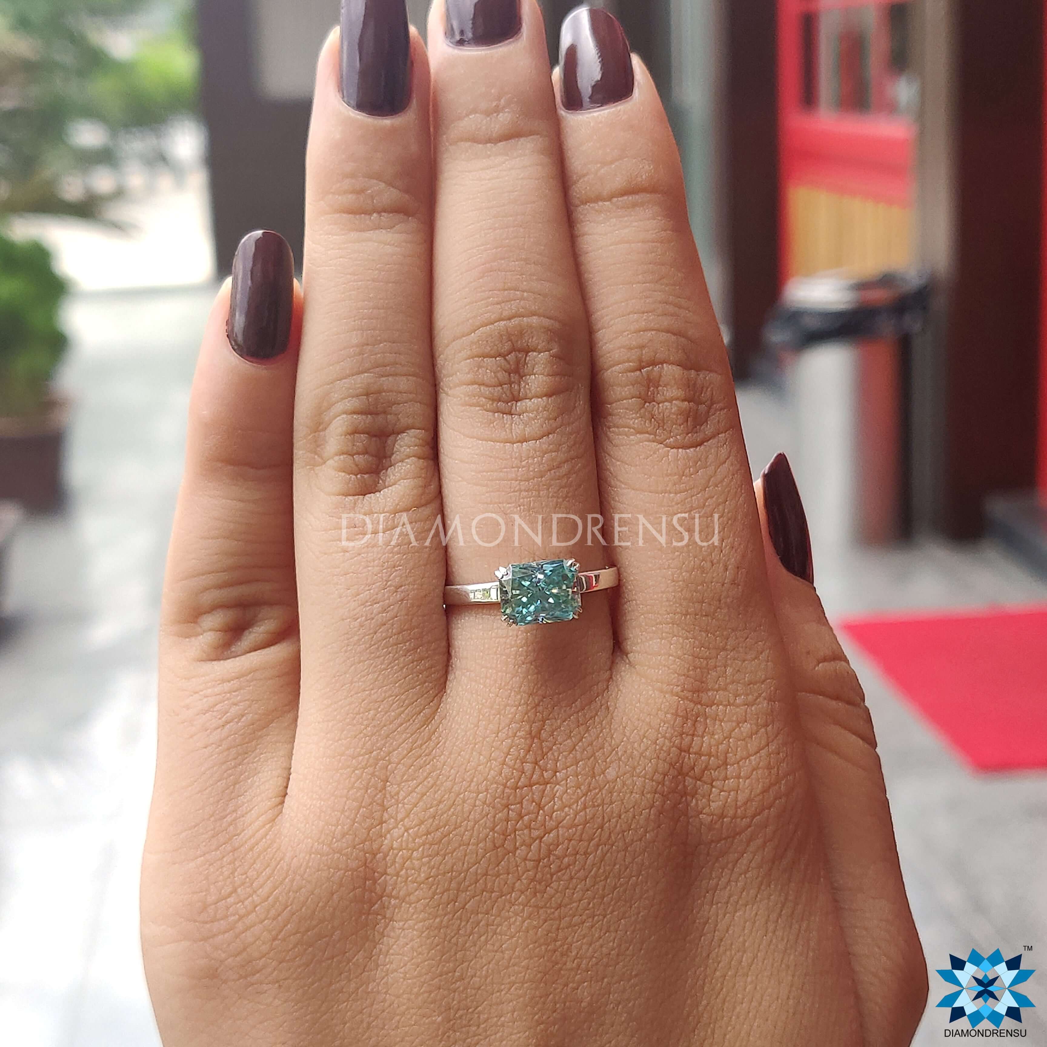 Handmade ring with a radiant cut moissanite center stone.