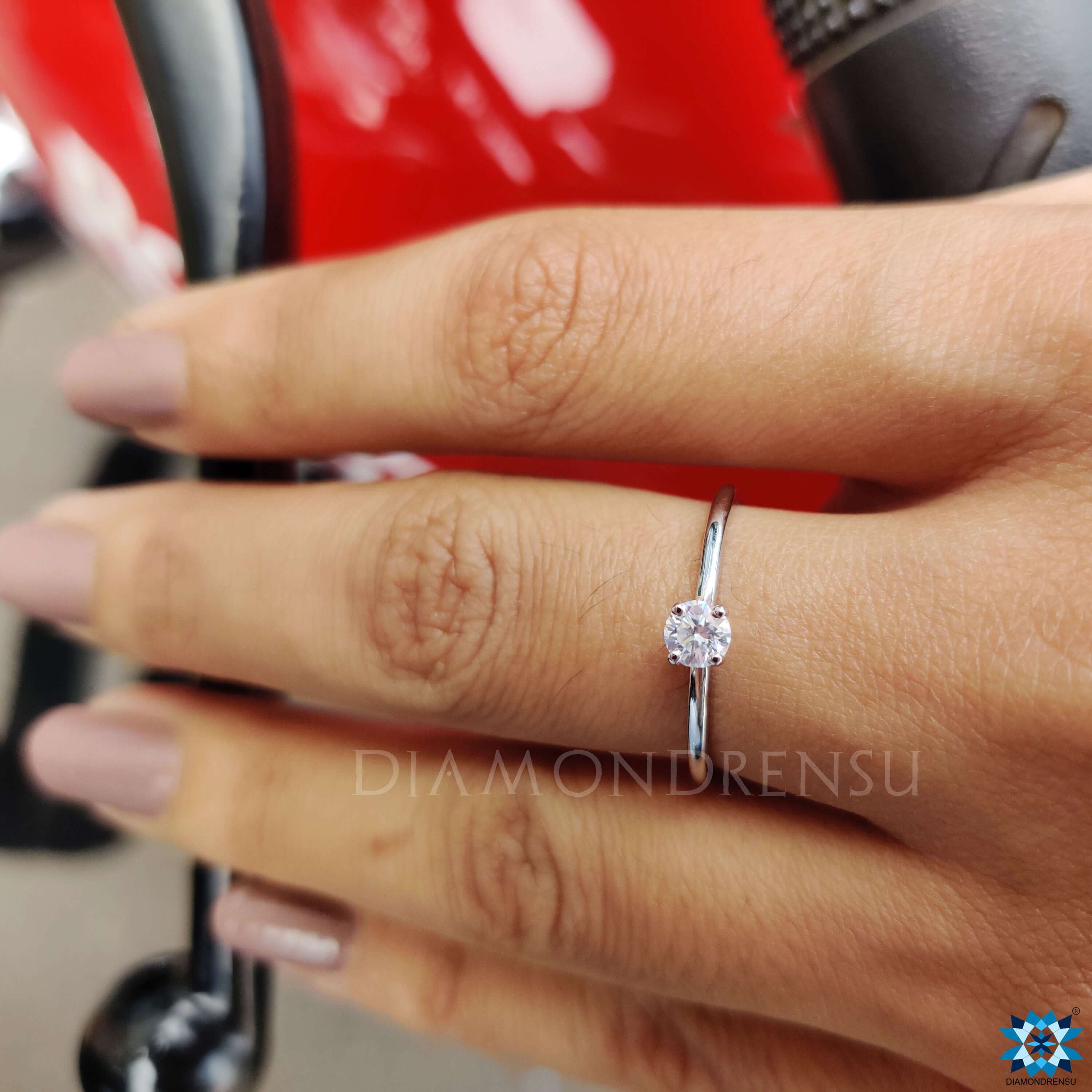 Solitaire round moissanite ring with four prongs.