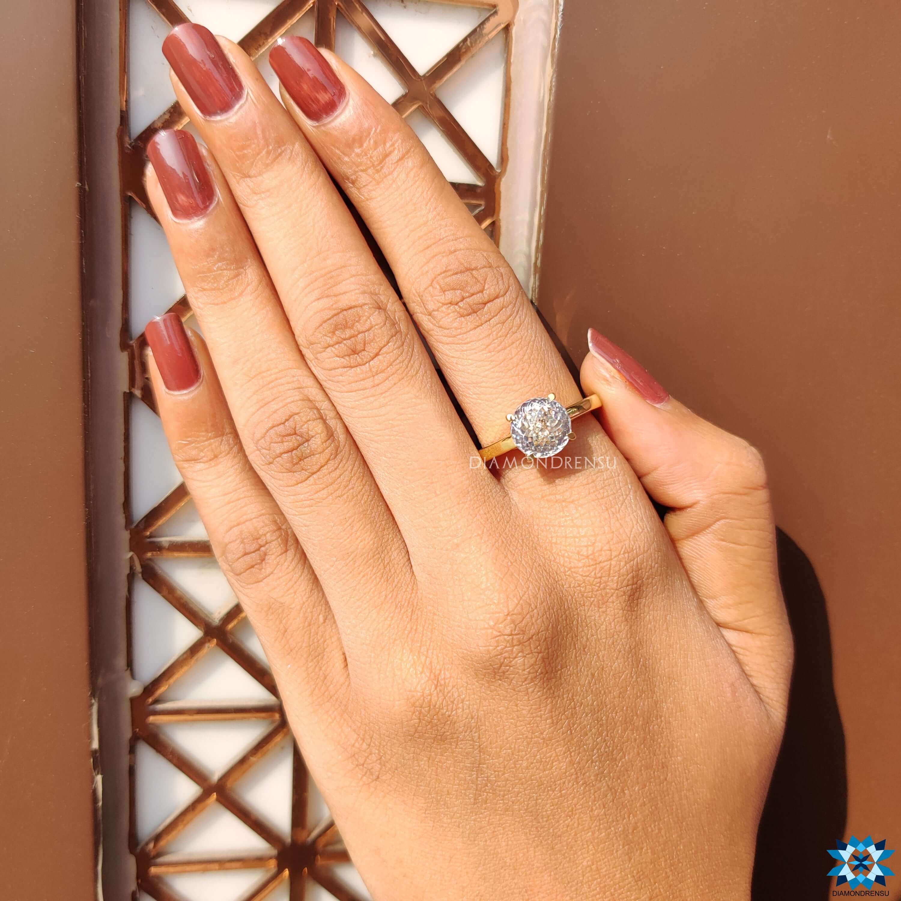 Four prong setting holding a Portuguese moissanite.