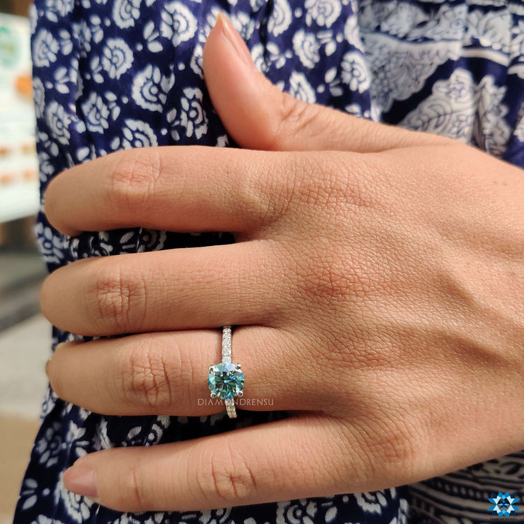 Cyan blue moissanite ring in pave setting.