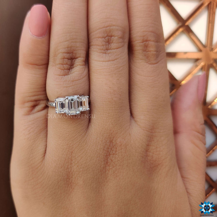 Emerald cut center stone with two emerald side stones.