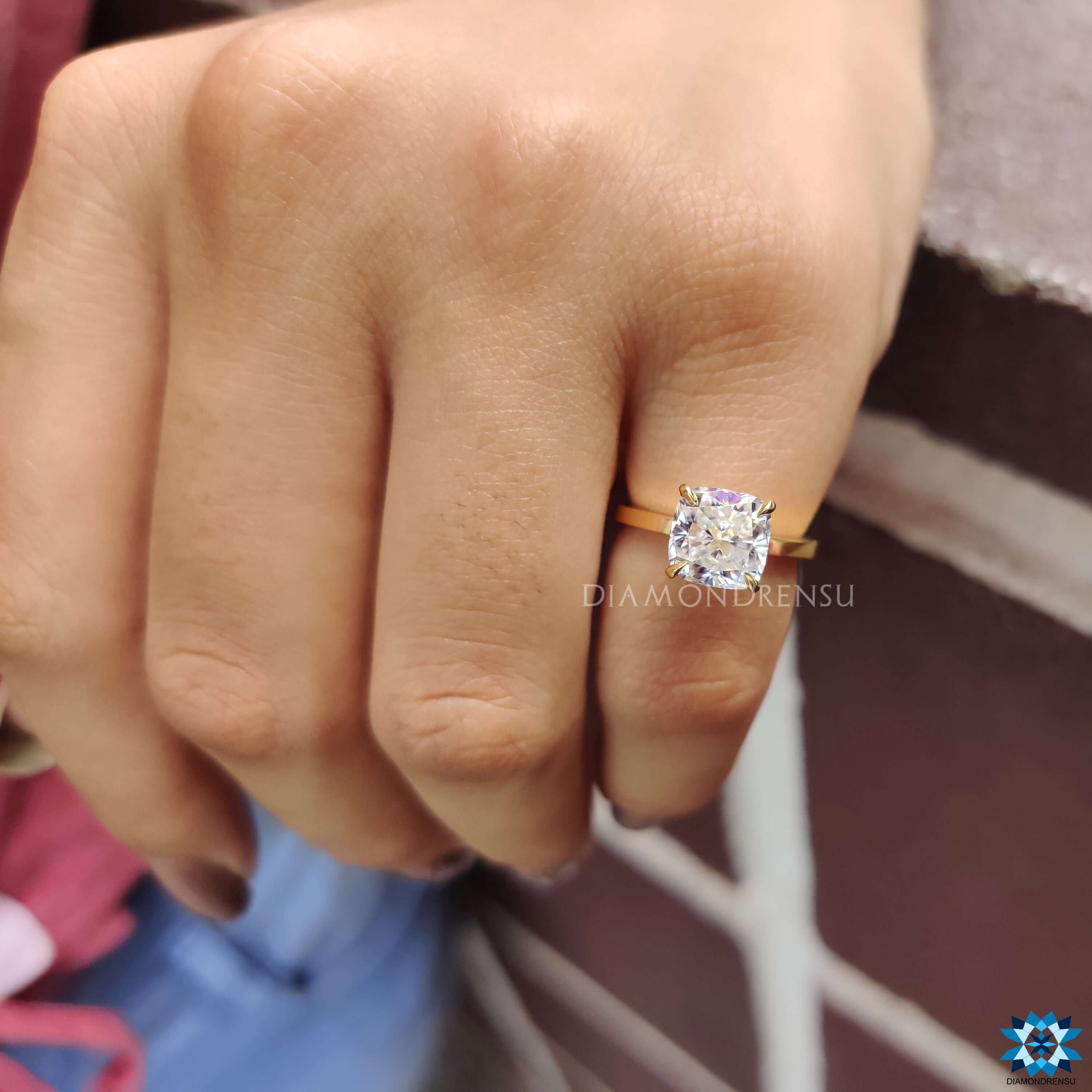 Cushion cut moissanite set in a classic solitaire yellow gold ring.
