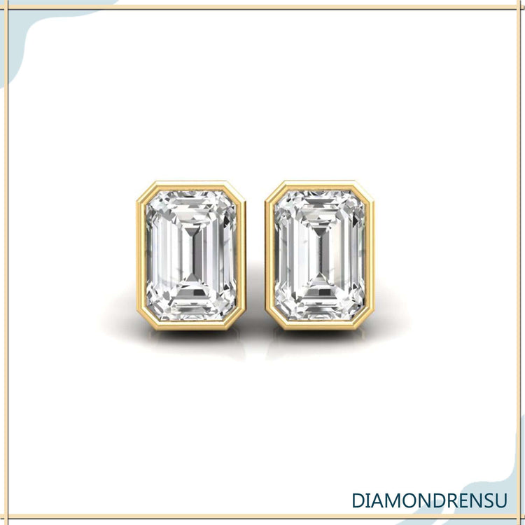 Gold stud earrings with bezel set emerald step cut diamonds.