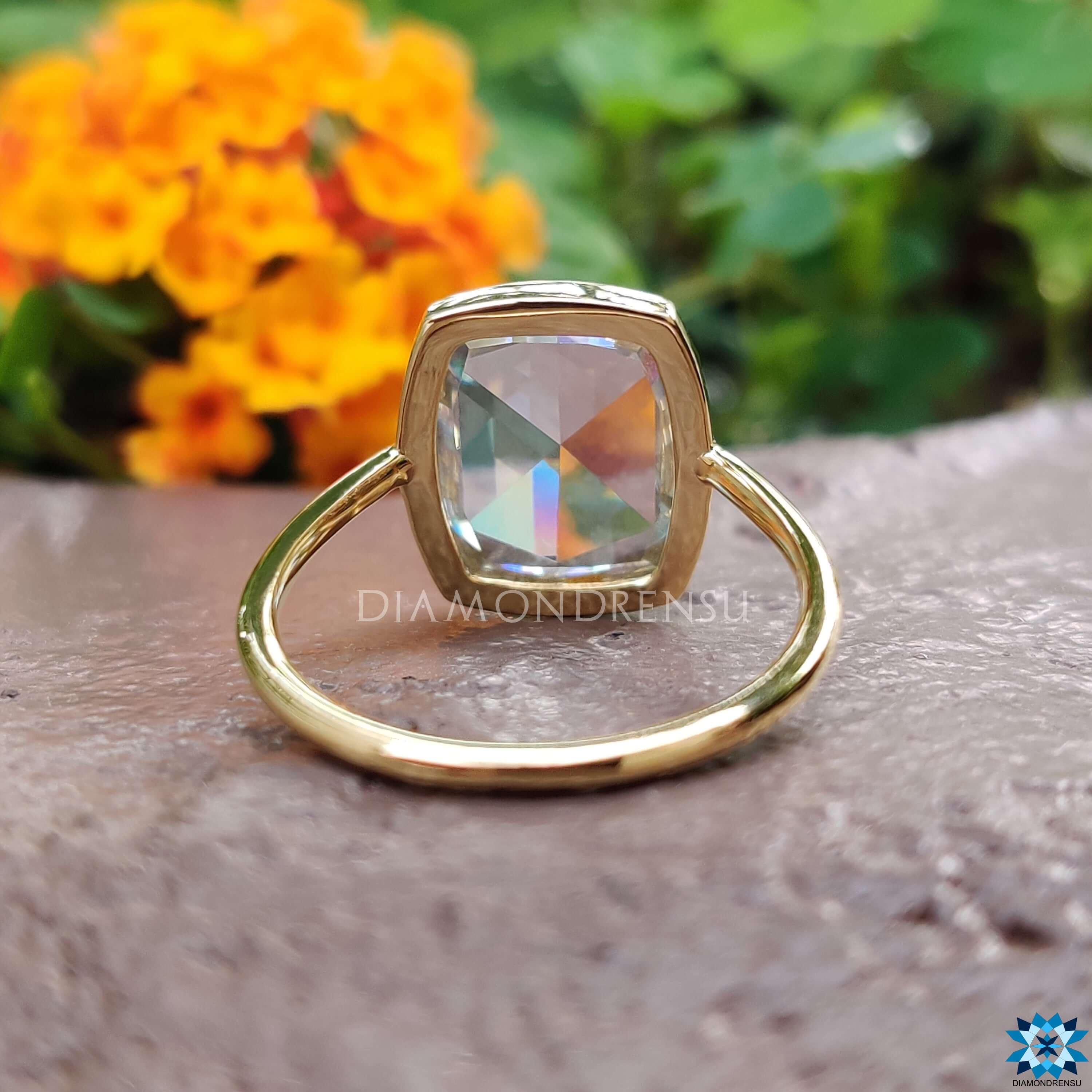 Off-white moissanite engagement ring with sleek bezel design.