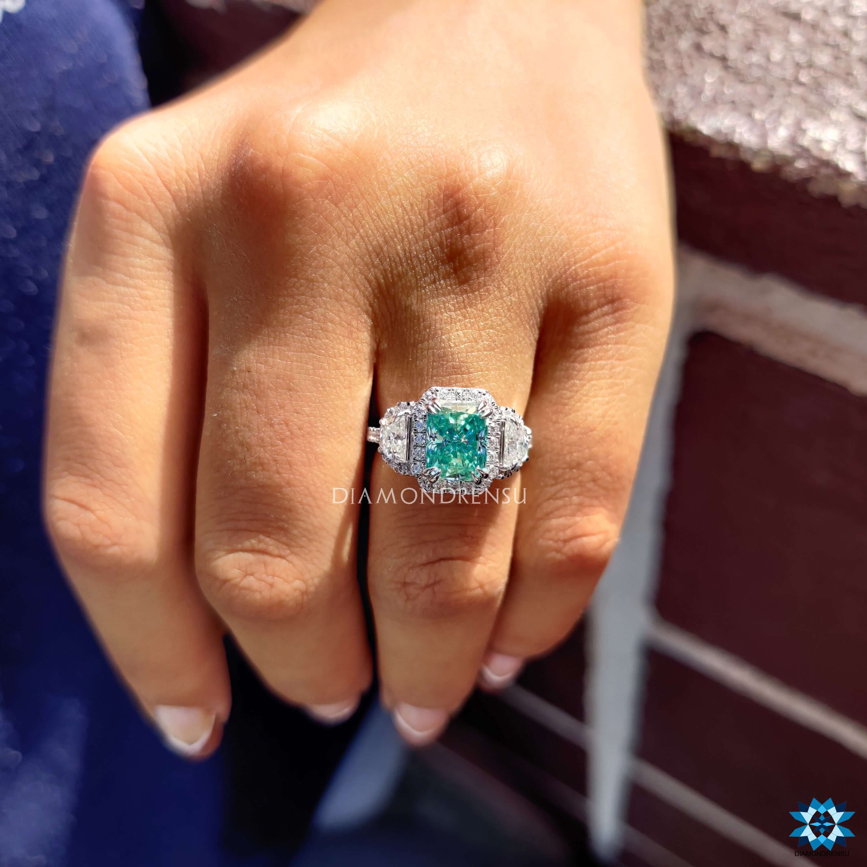 Radiant cut cyan moissanite engagement ring in white gold.