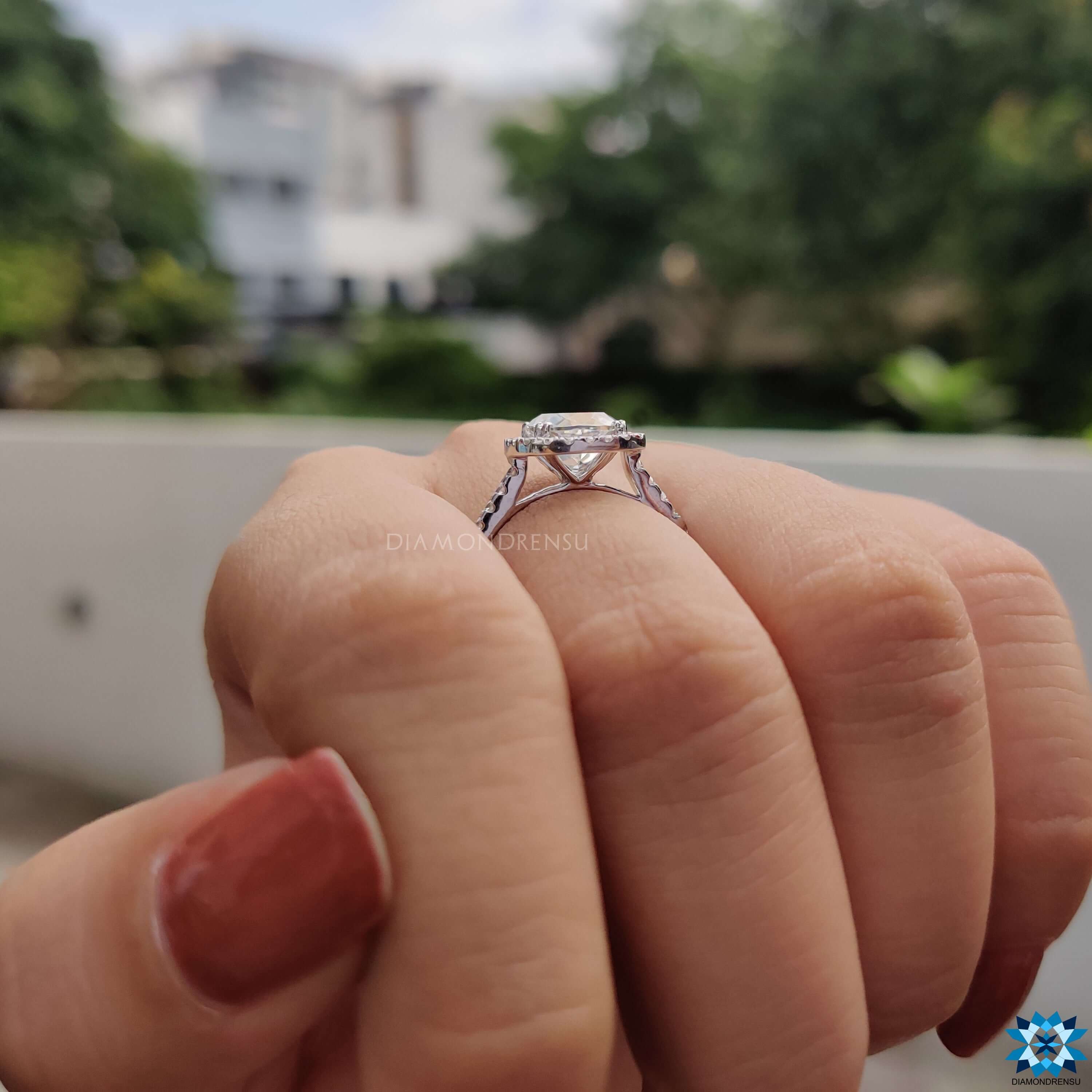 Double prong setting ring featuring cushion cut moissanite in halo style.