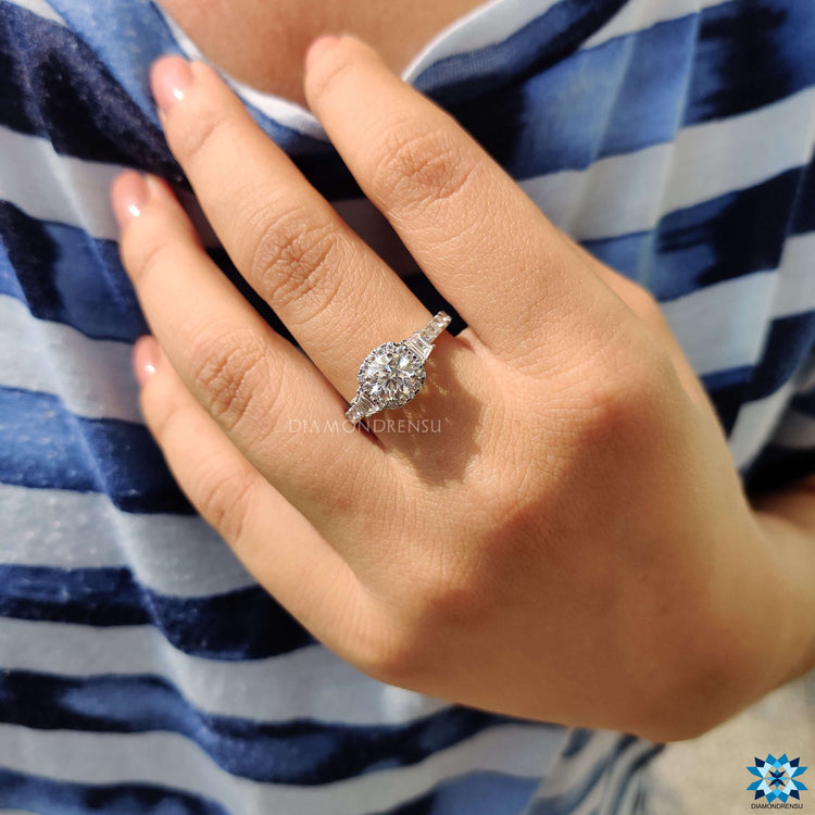 Round cut moissanite engagement ring with detailed halo and pave finish.