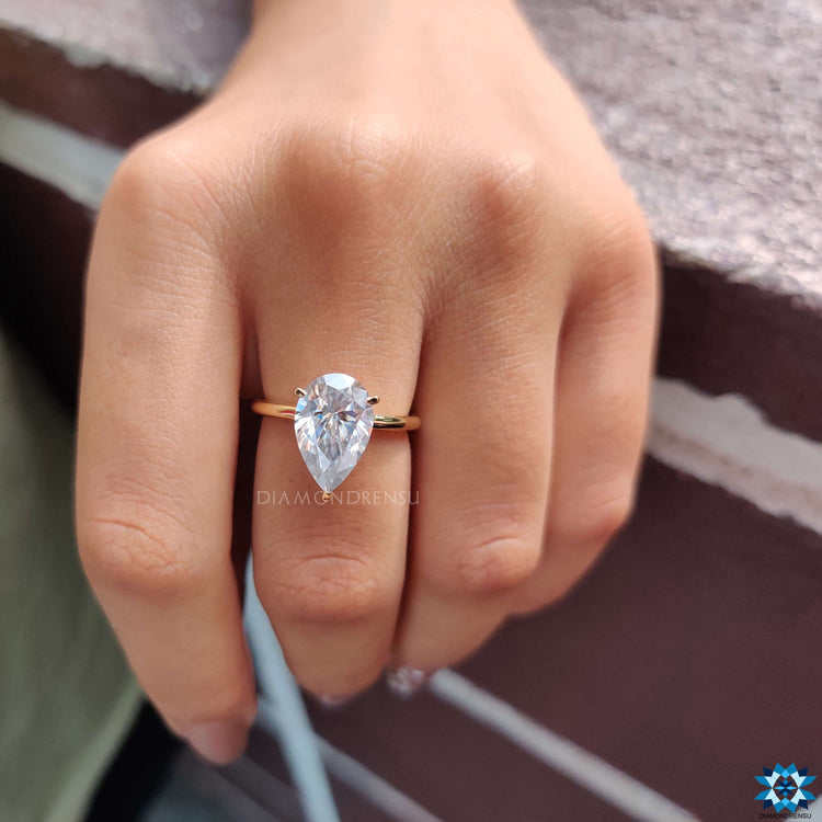 Moissanite engagement ring with three claw prong mount.