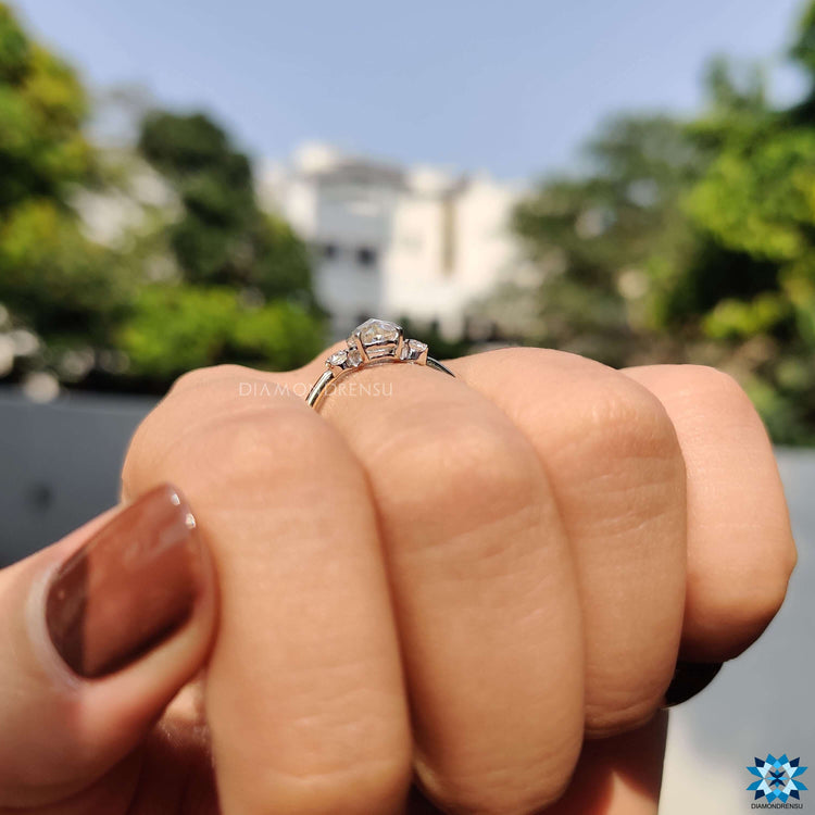 Custom moissanite engagement ring with two-tone metal and 4 tab prongs.