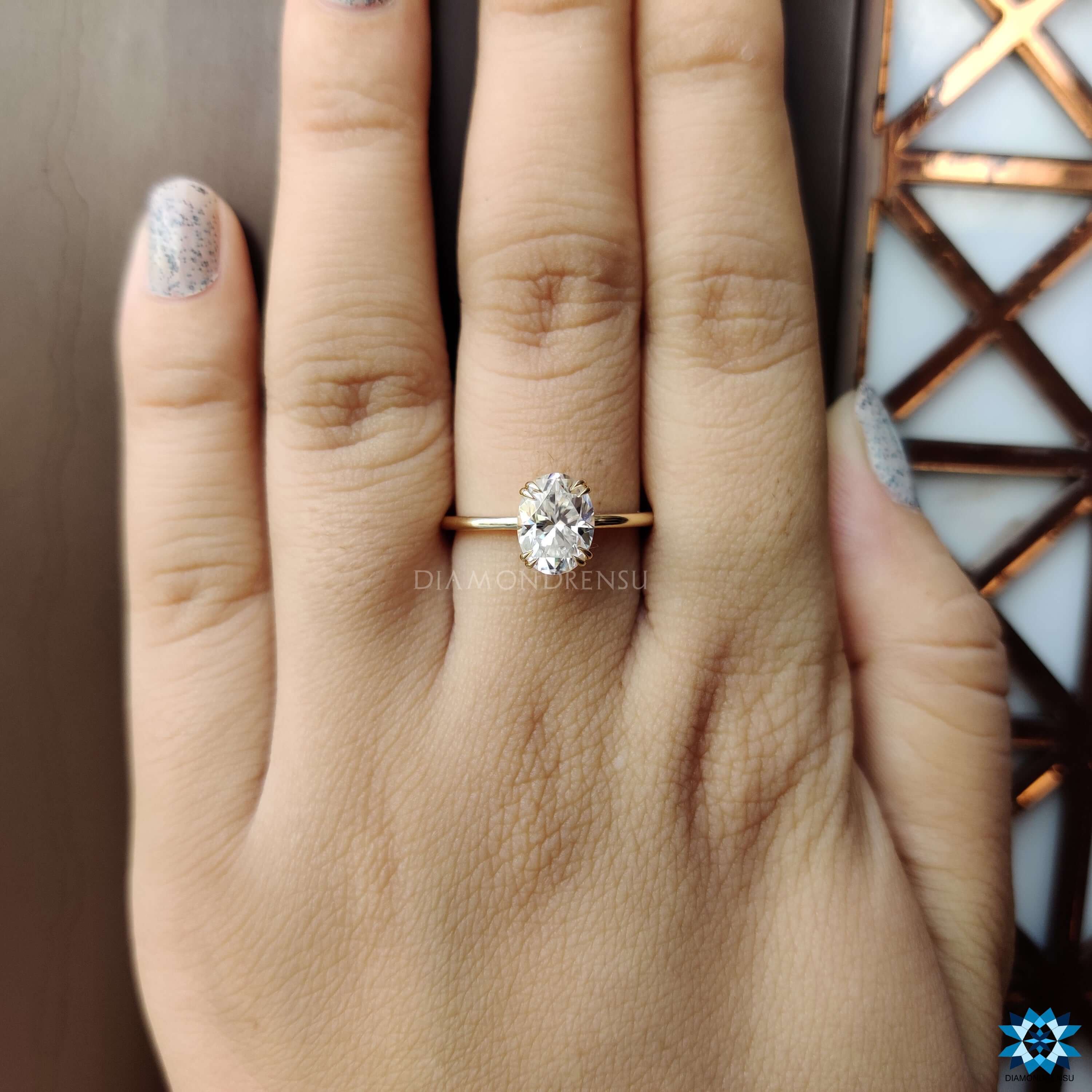 Simple yellow gold ring with oval moissanite solitaire.