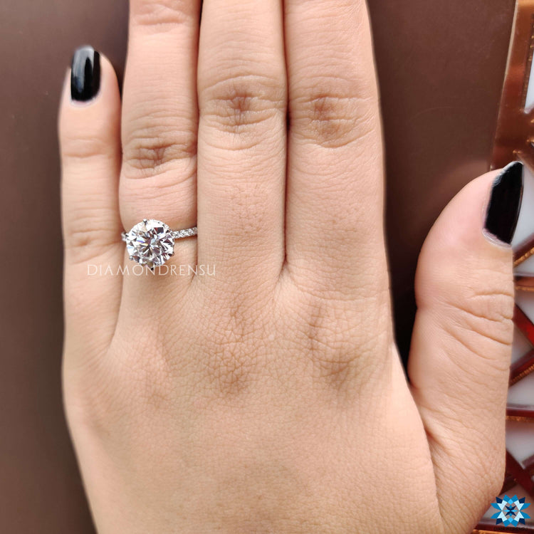 Elegant 6 prong round cut moissanite ring with halo detail.