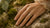 Nature inspired engagement ring worn on hand over moss