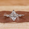 Marquise engagement ring with marquise and round side stones.

