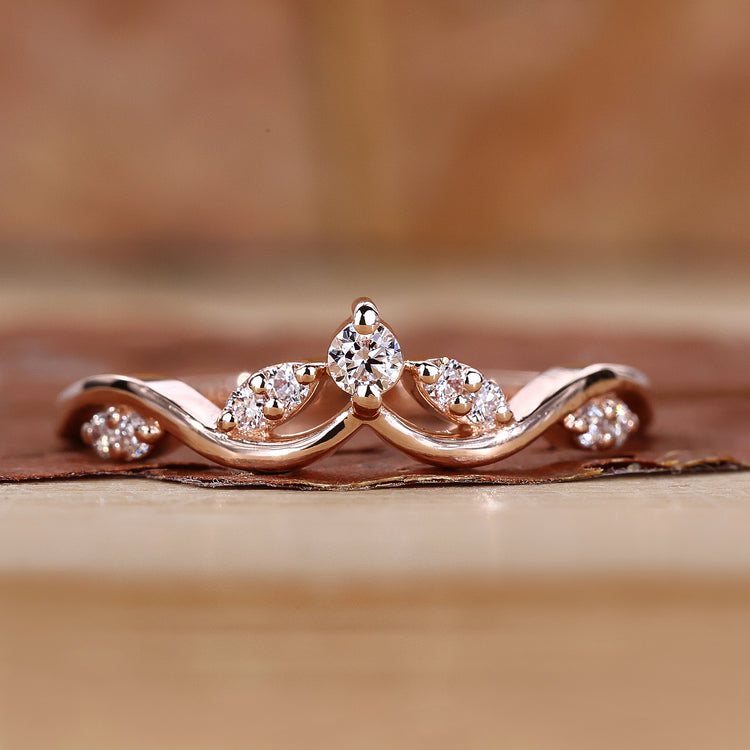 Curved wedding band with round cut diamonds.
