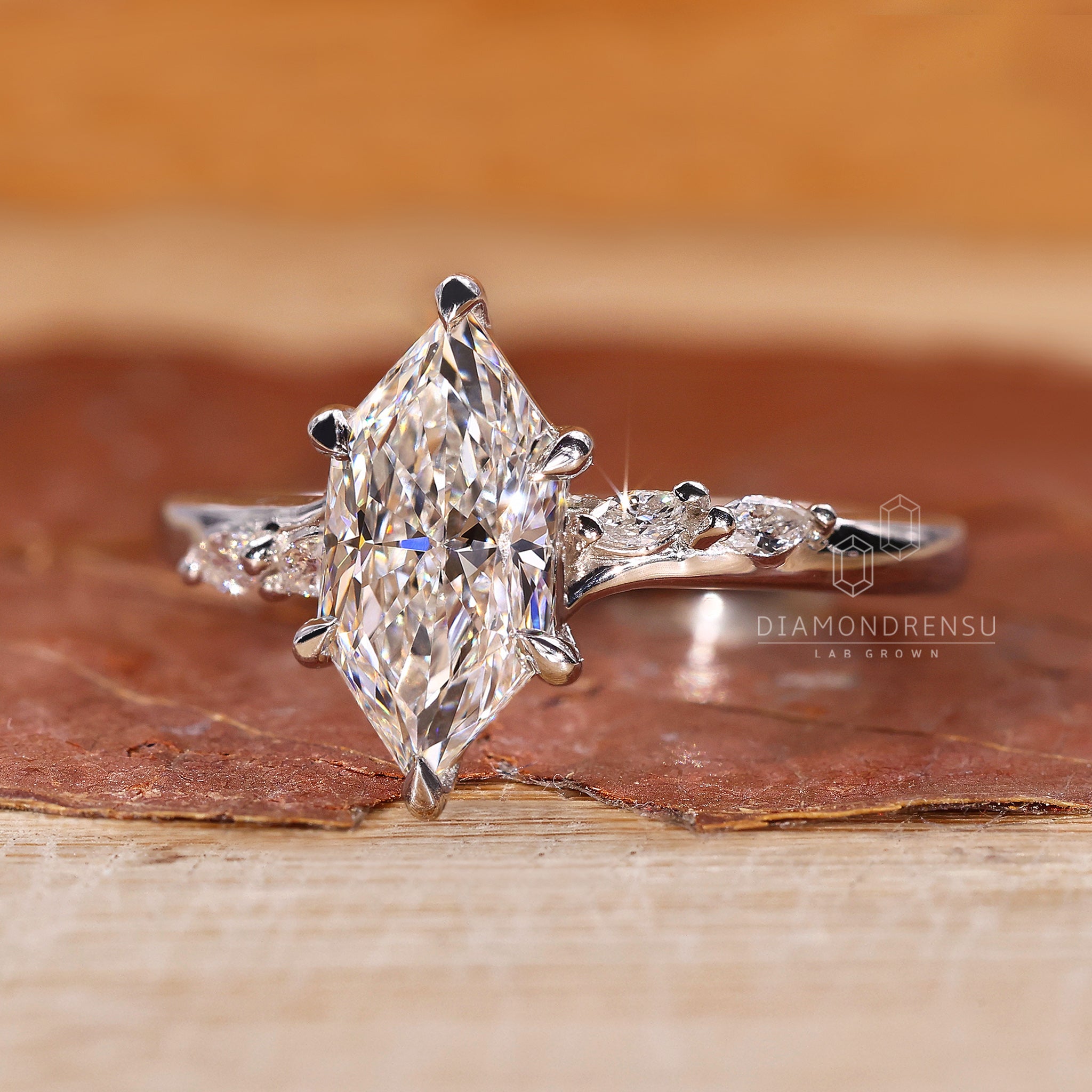 Buy engagement ring featuring marquise and round side stones.

