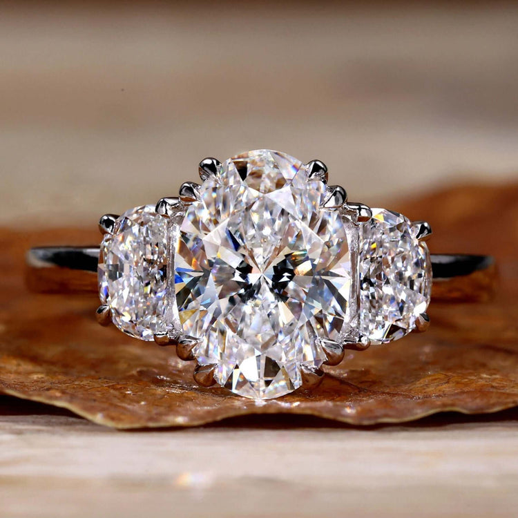 2 Carat Oval Diamond Ring with two half moon side stones, perfect for a unique engagement ring design.
