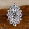 Cluster engagement ring with marquise cut diamond and prong setting for a timeless and elegant look.
