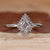 Halo diamond engagement ring with lozenge cut diamond center stone.
