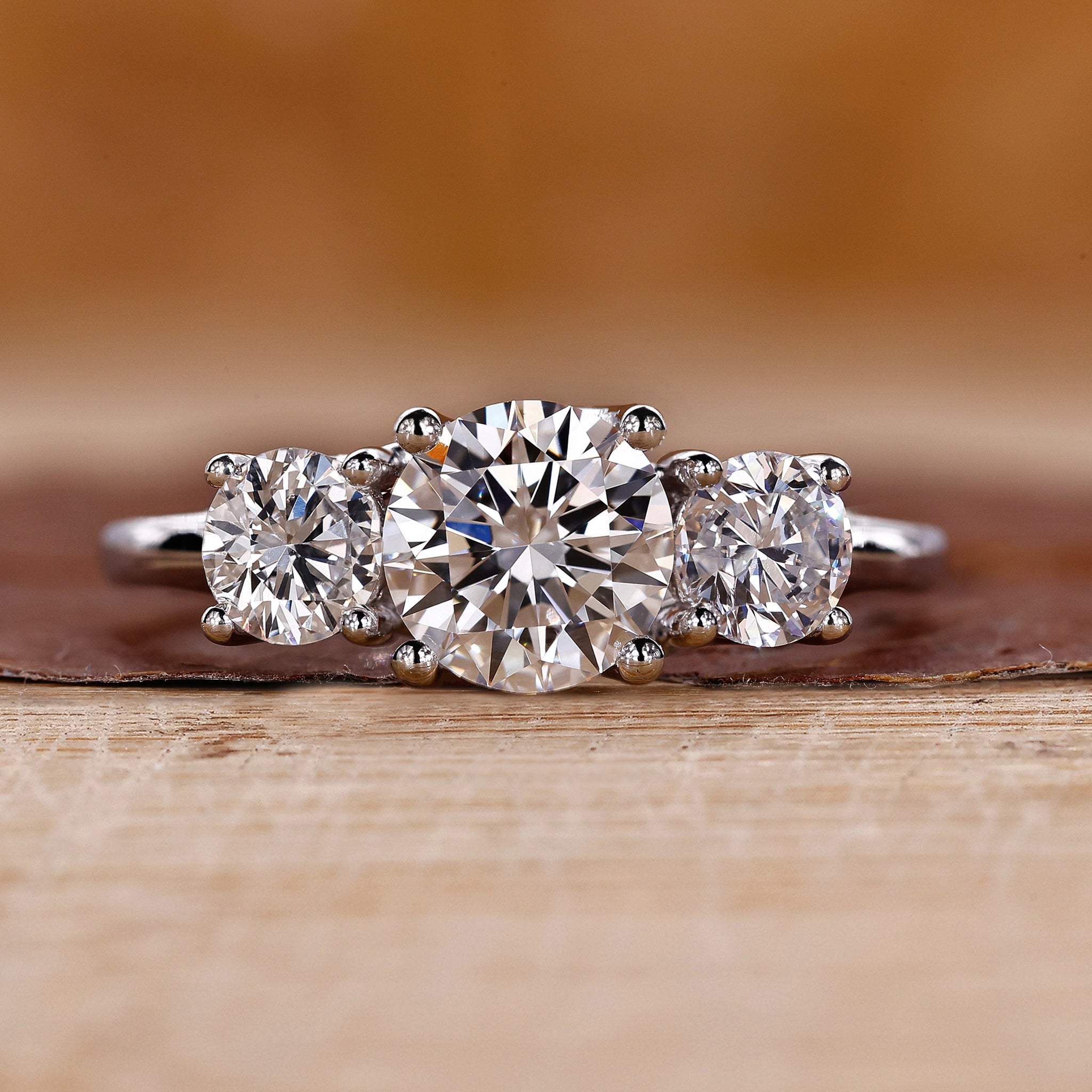 3 stone round diamond ring with trellis setting in white gold.
