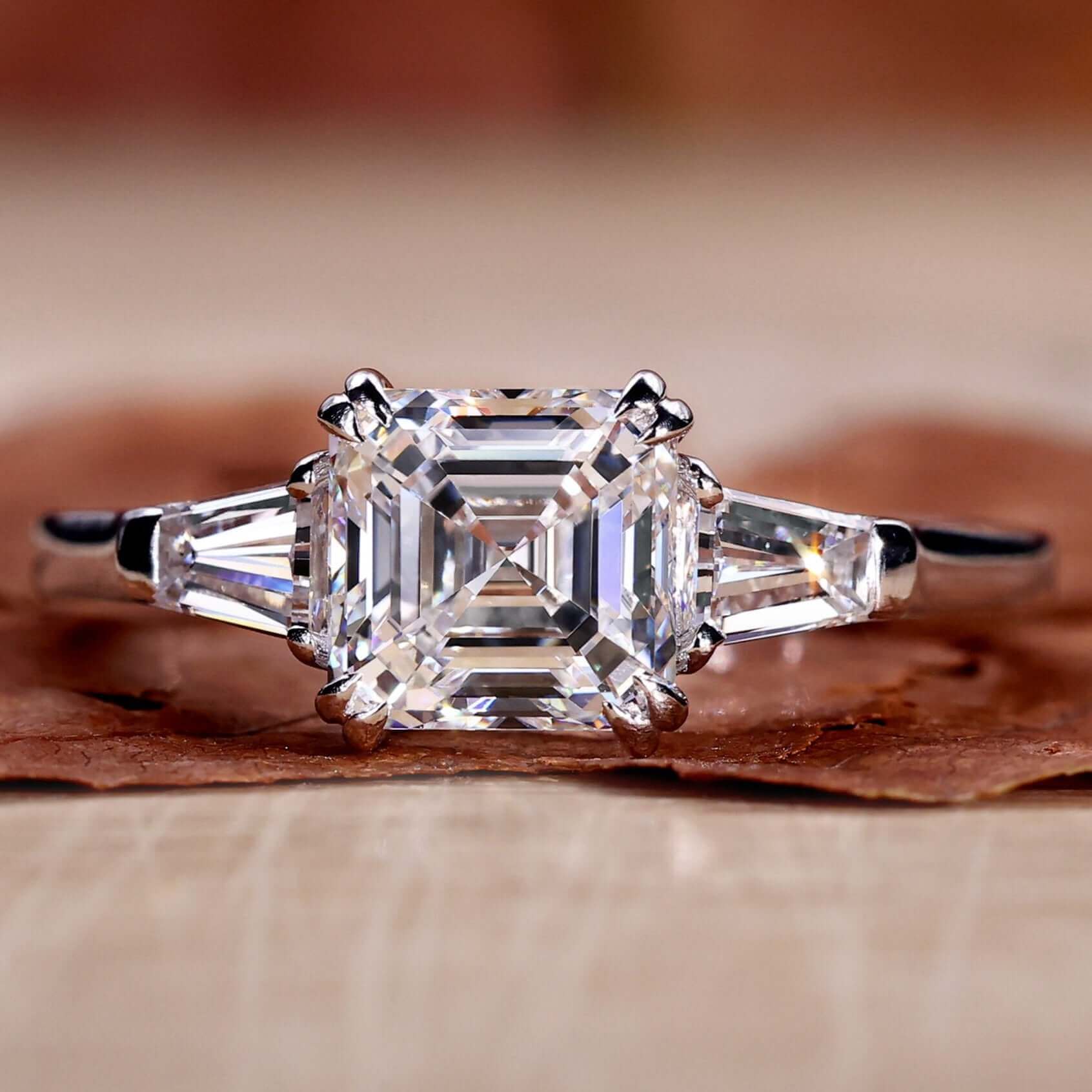 Asscher cut diamond ring paired with a tapered baguette engagement ring design for timeless elegance.
