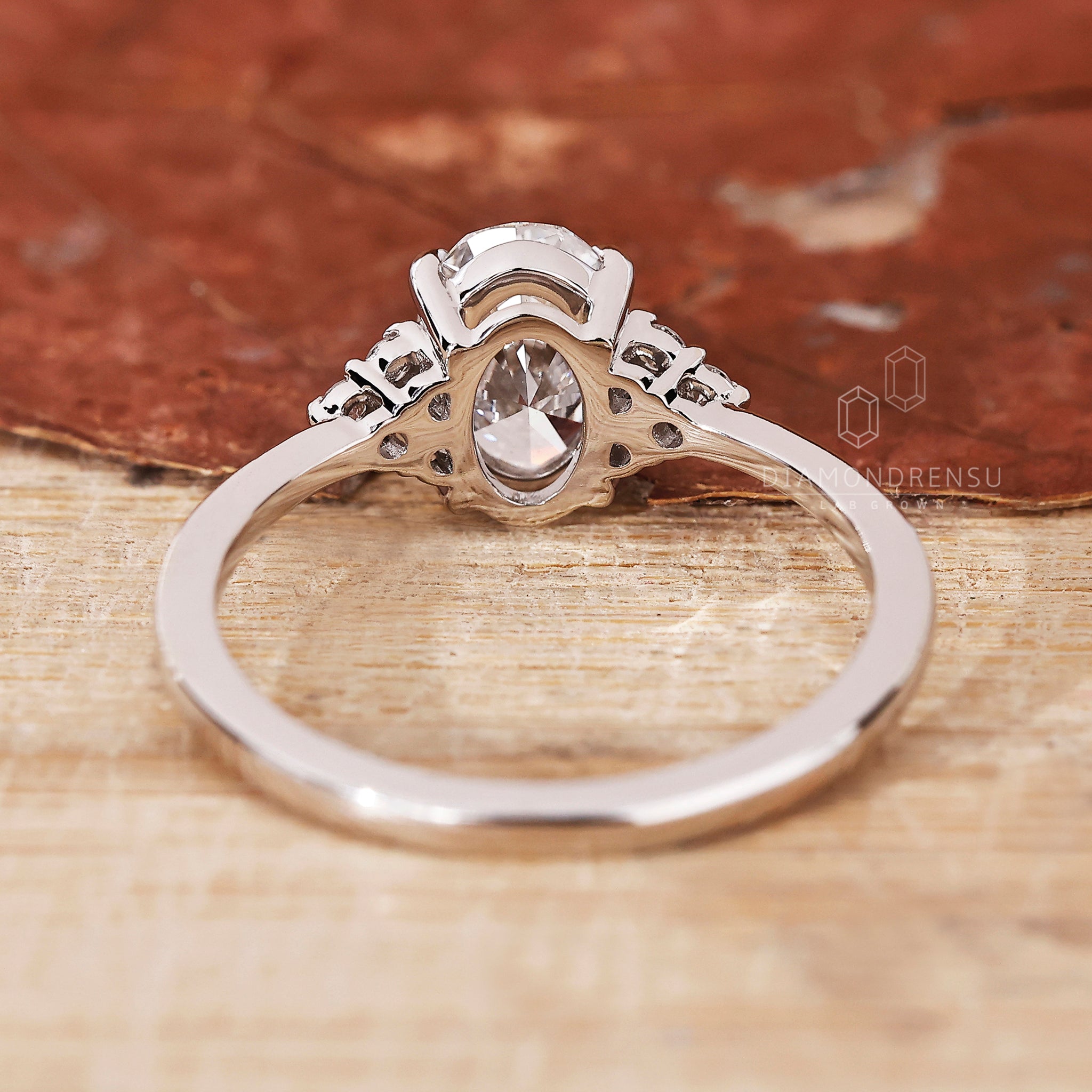 Round side stone ring with muse setting and handmade jewellery details.
