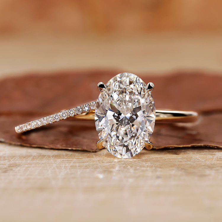 Oval engagement ring with wedding band in yellow gold bridal set.
