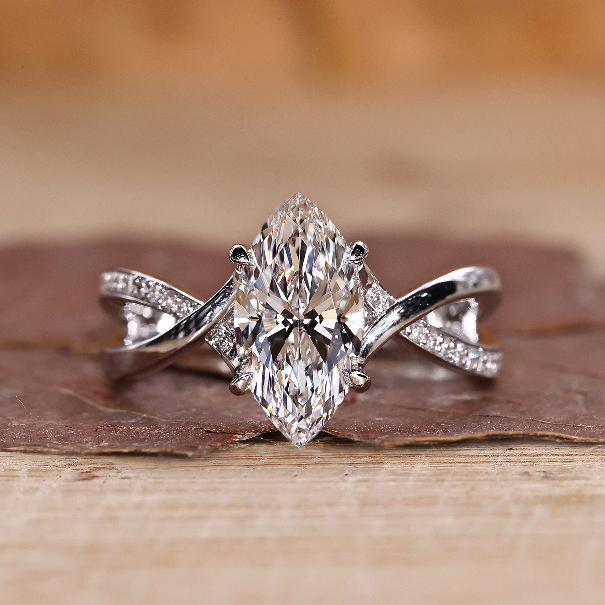 Marquise cut diamond ring with twisted pave engagement design.
