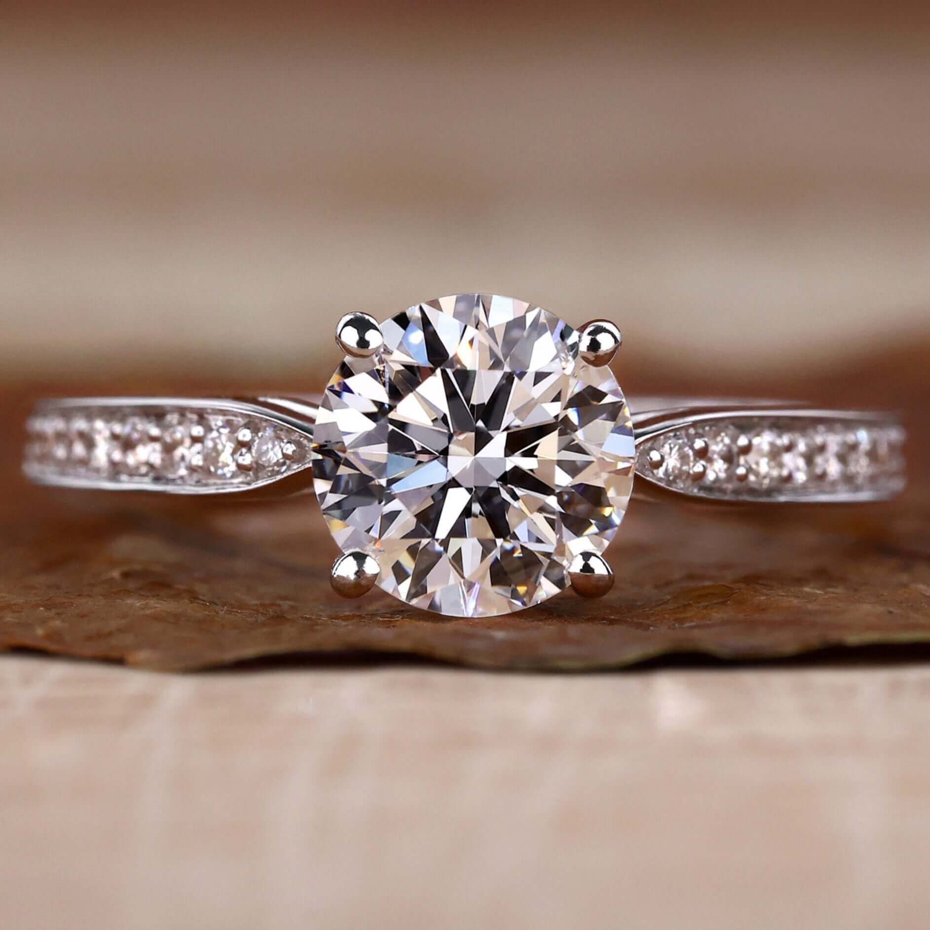 Tapered pave engagement ring featuring a round brilliant cut diamond ring with a stunning 4 prong diamond setting.