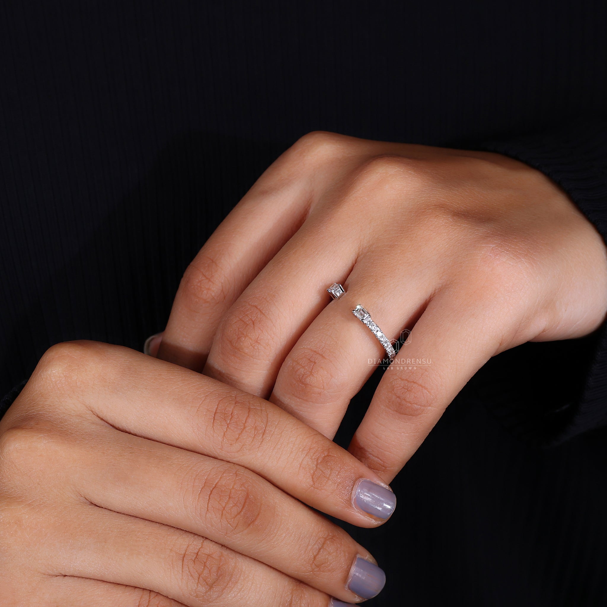 Open wedding band with lab grown emerald and round diamonds
