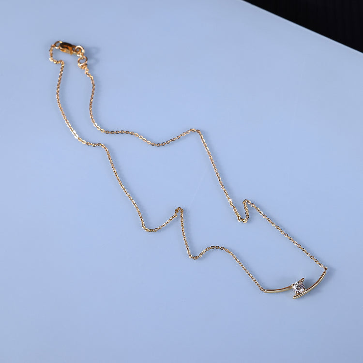 Yellow gold pendant featuring a round cut diamond in a modern bar shape.
