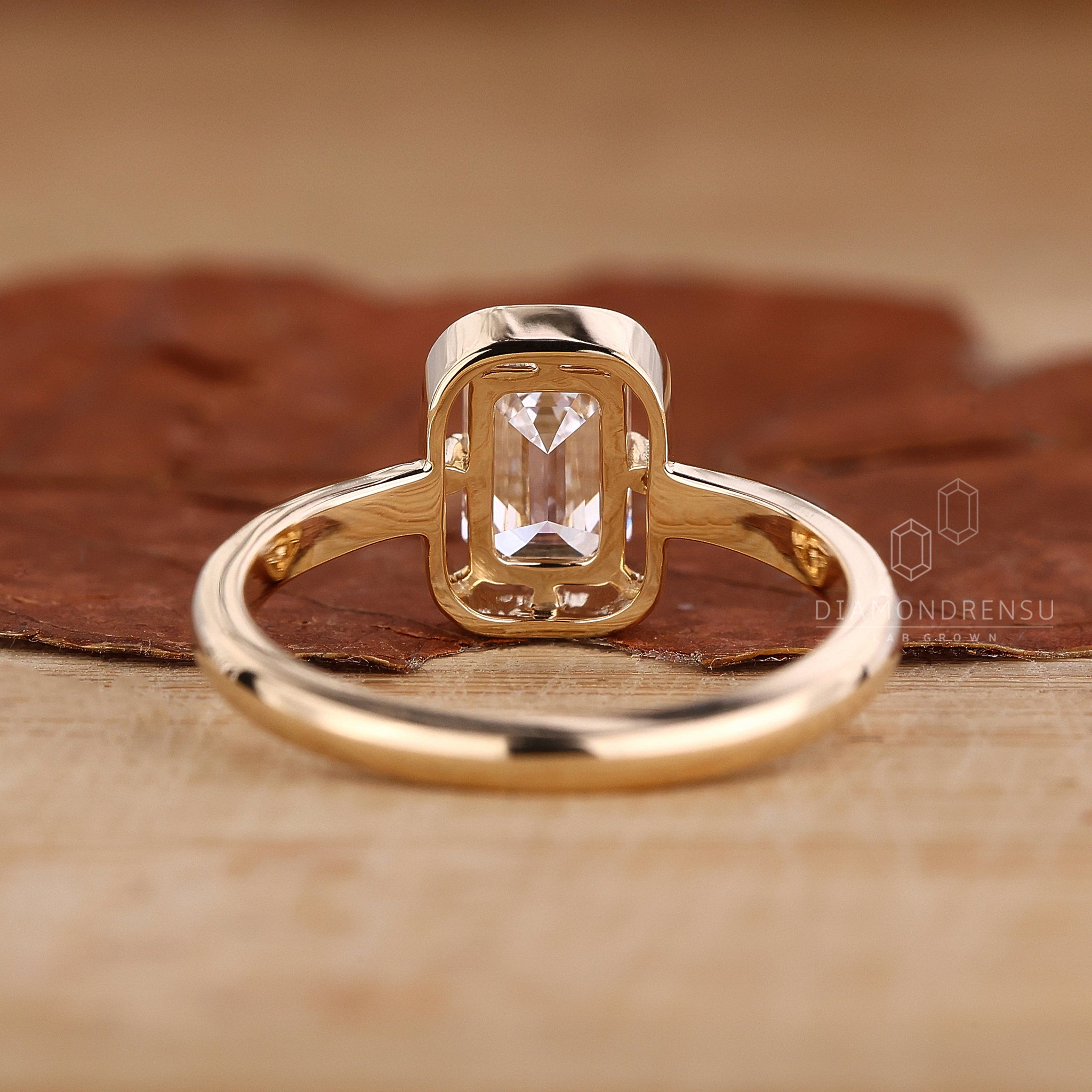 Unique engagement ring has emerald cut and solitaire setting.
