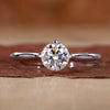 Close-up of round solitaire diamond ring with compass prongs setting