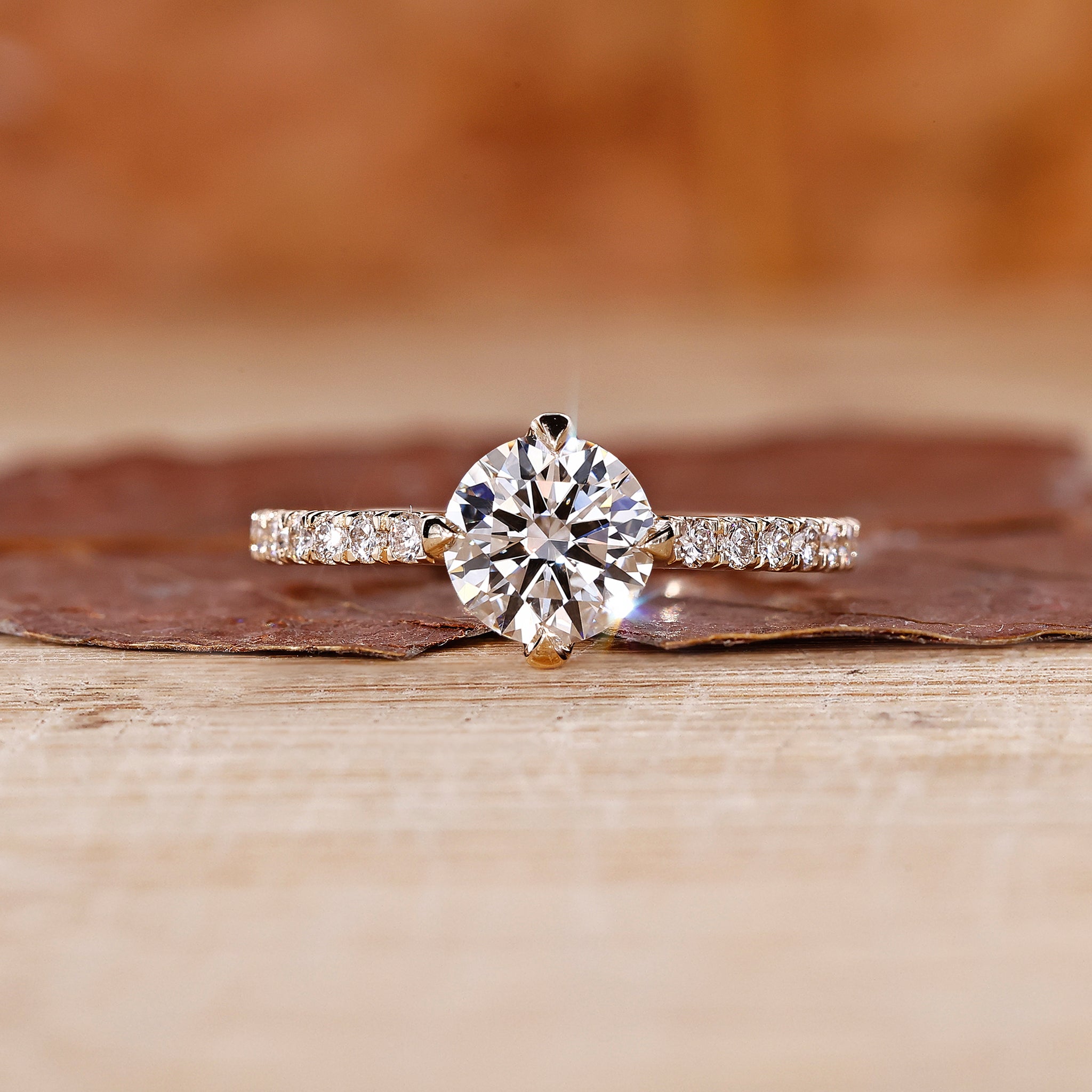 Round diamond ring with pave set band in yellow gold.
