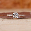 Round diamond ring with pave set band in yellow gold.
