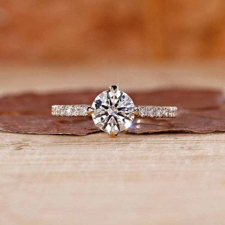 Round diamond ring with pave set band in yellow gold.
