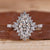Marquise halo engagement ring with pave setting in white gold.

