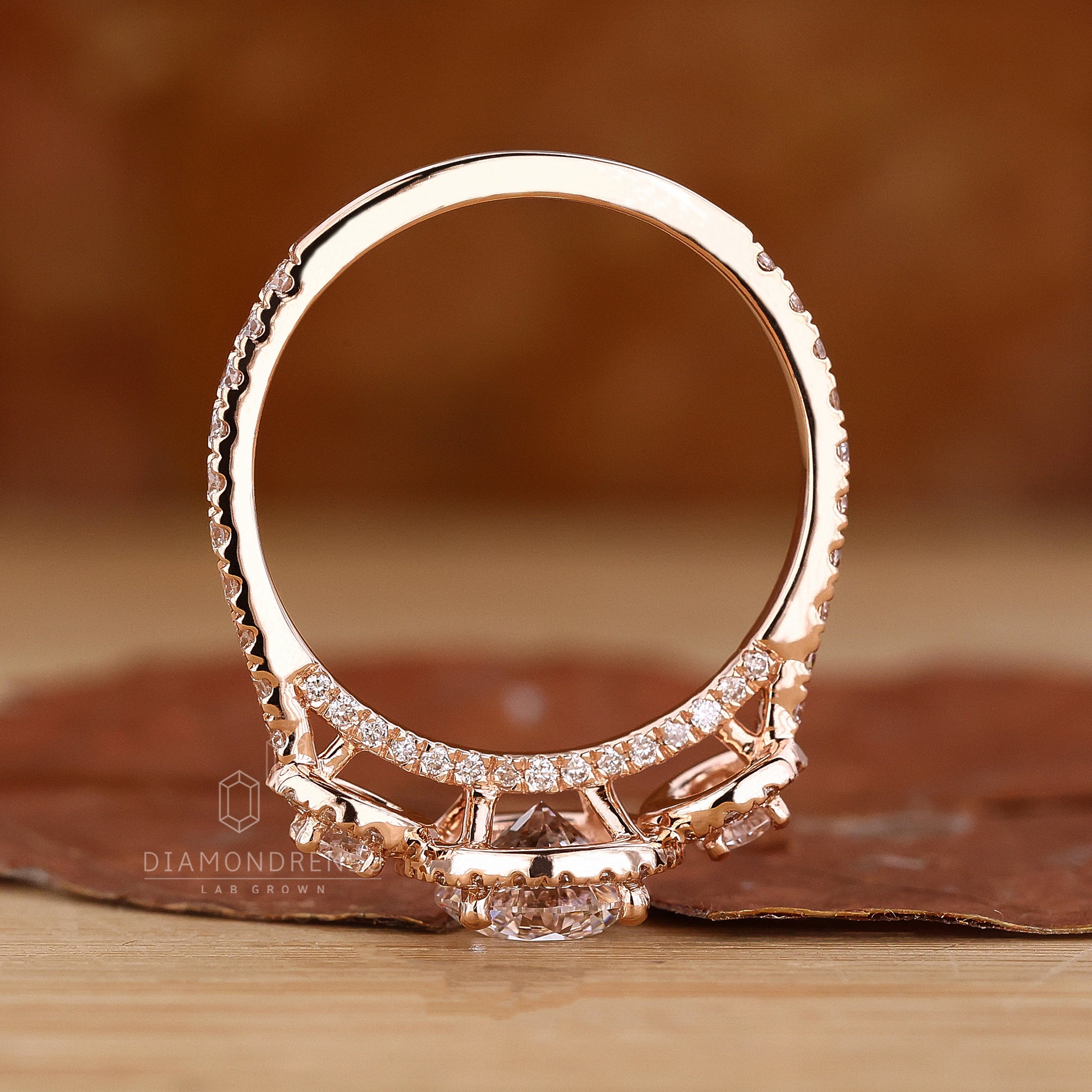 3 stone halo design in rose gold setting.
