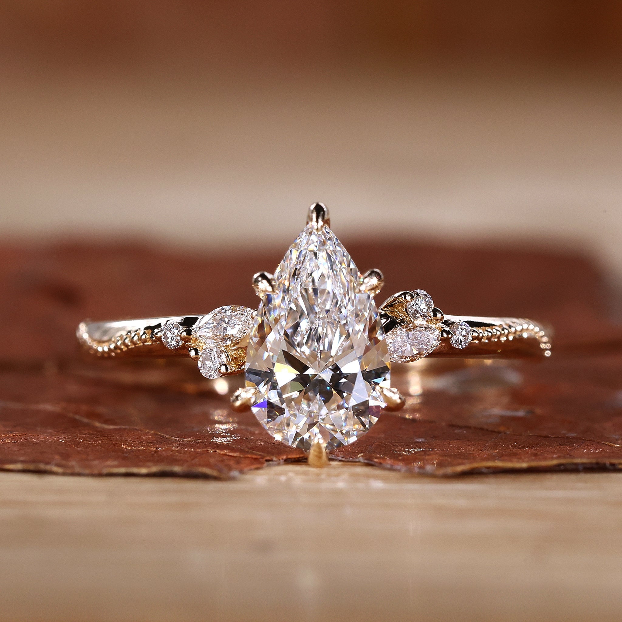 Close-up of a pear cut diamond ring with round and marquise side stones