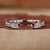 Open wedding band with emerald and round cut diamonds
