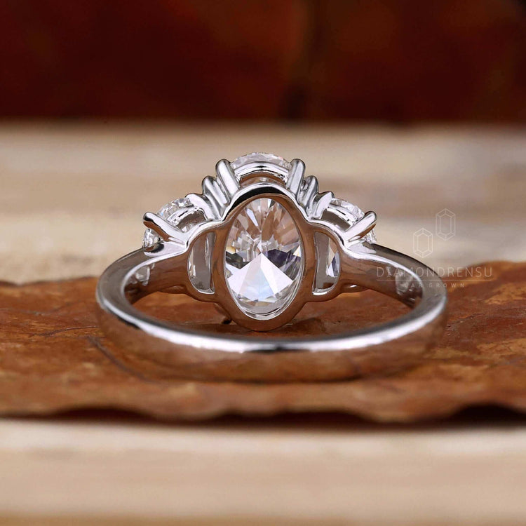 3 stone engagement ring design featuring an oval diamond and unique two half moon side stones for timeless elegance.
