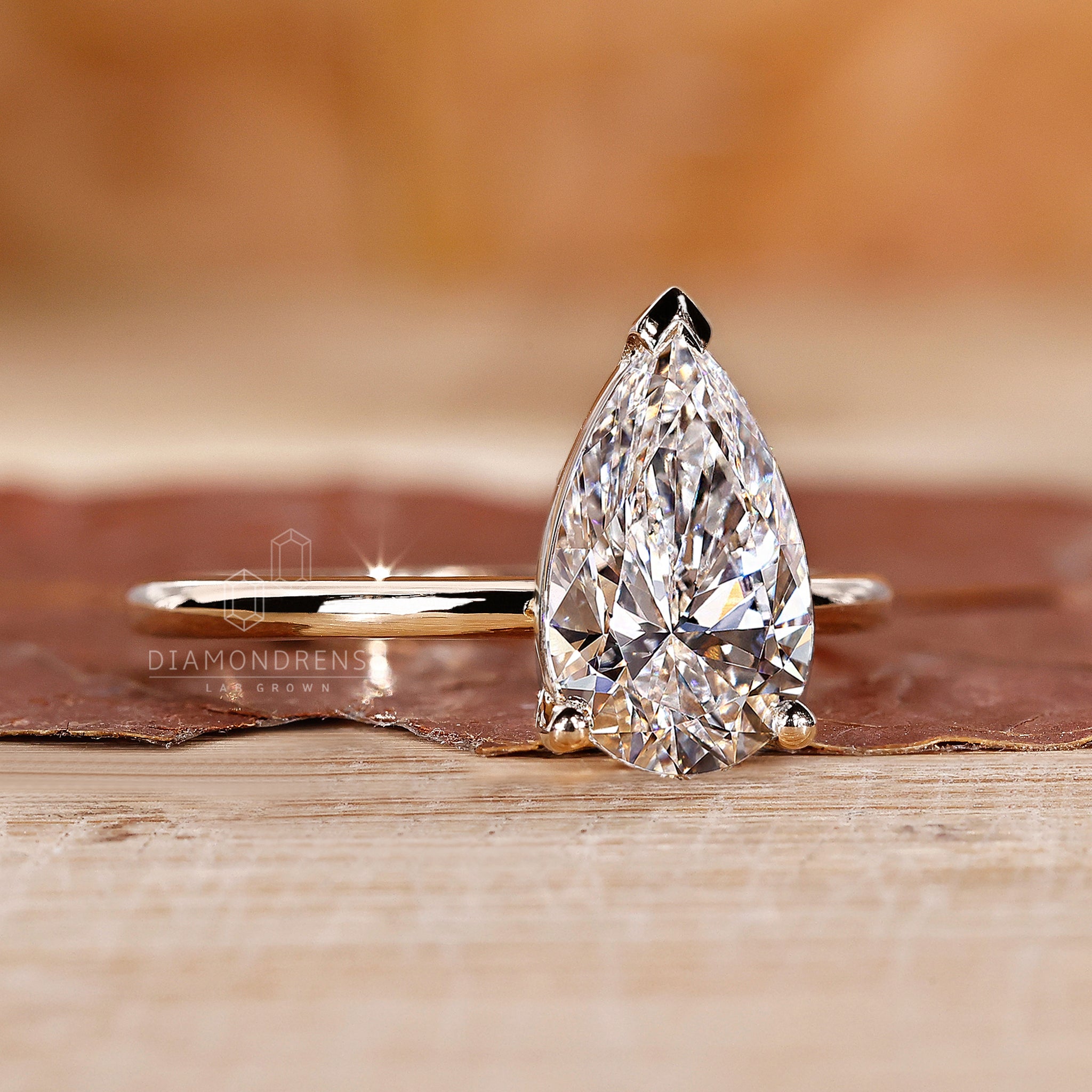 V prong ring featuring a lab grown pear cut diamond.
