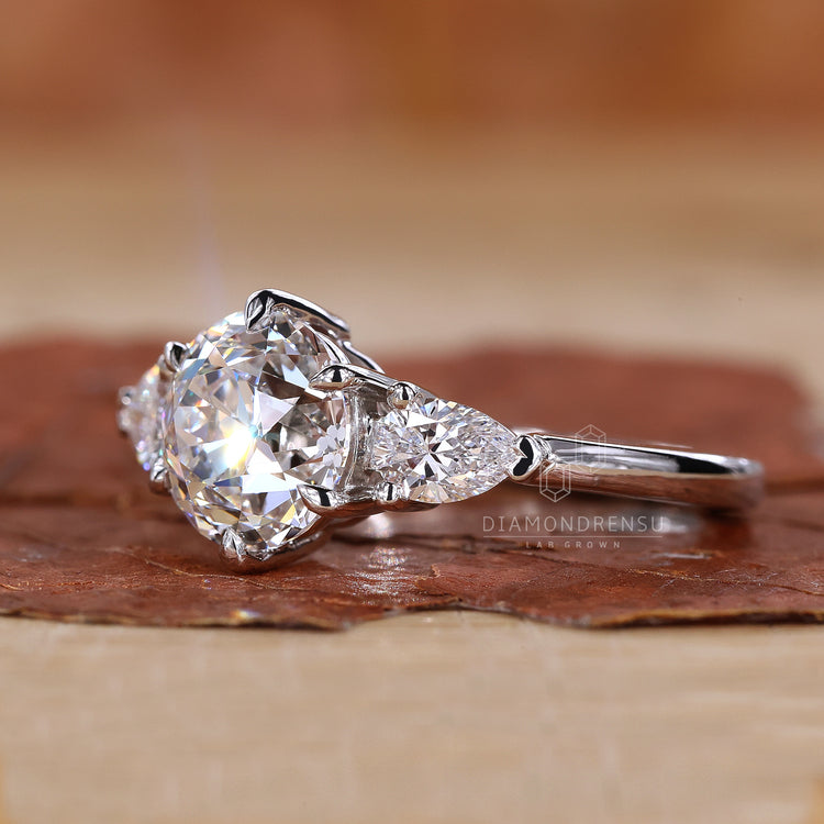 Two pear cut side stones with round center.
