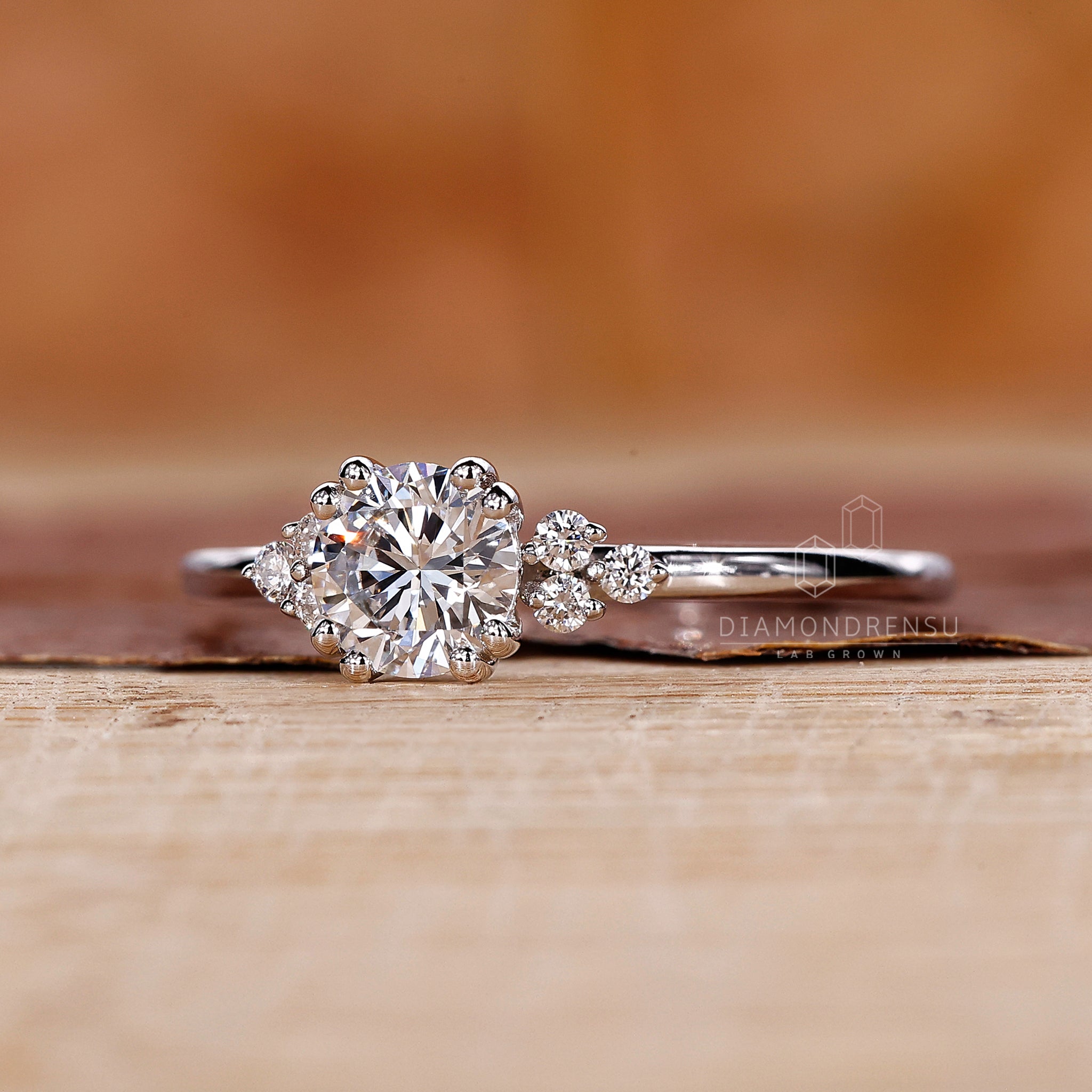 UK engagement ring in white gold with round diamond and side stones.
