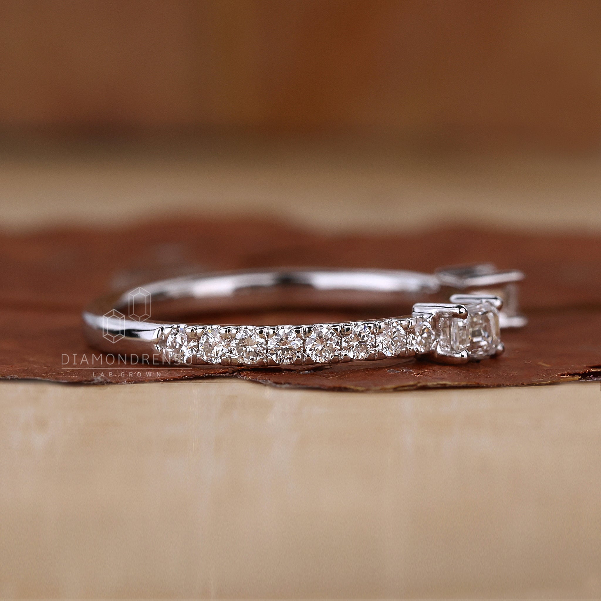 White gold wedding band featuring emerald and round cuts
